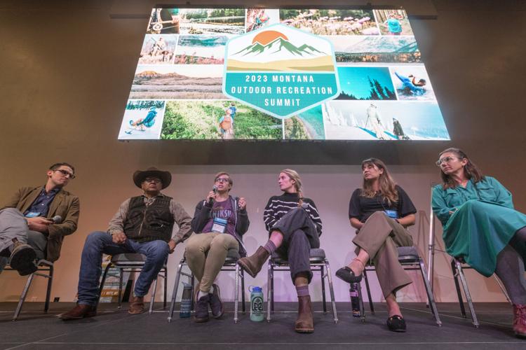 Six people sit on a stage, under a sign that reads "2023 Montana Outdoor Recreation Summit".